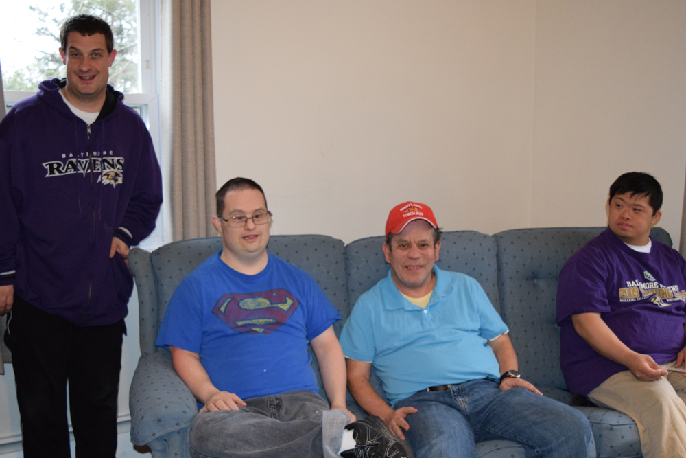 Four young men with intellectual disability smile in a Gallagher home