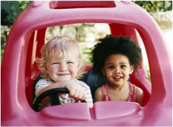 Two children sit together in a car. Donate to Catholic Charities.