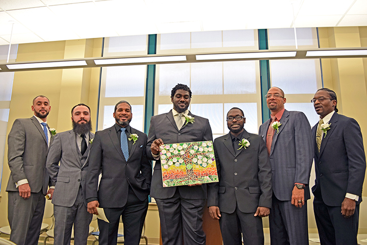 Graduates of the 79th Capstone Class of Christopher Place Employment Academy, including (l-r): Tarrey Saunders, Hadi Sadeghiasl, Vernon Smith, Corey Williams, Qymaine Harden, Dartanian Byrd, and Charles Cole, present a mosaic they created as part of their hands-on learning in Art with a Heart.